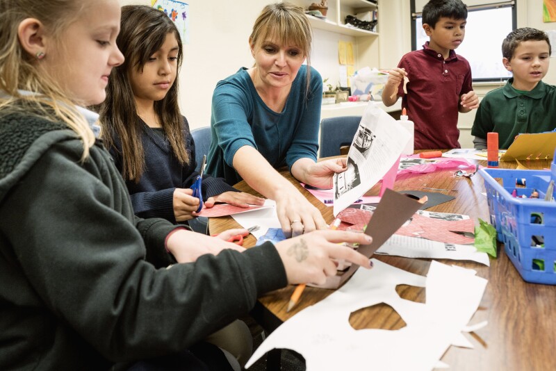 Teacher assisting students in art class